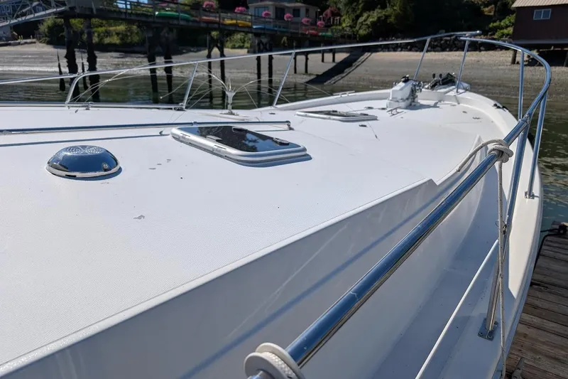 Slide: The Image of 1989 Bayliner 3888 Motoryacht deck view with railing, docked near a wooden pier. - 4