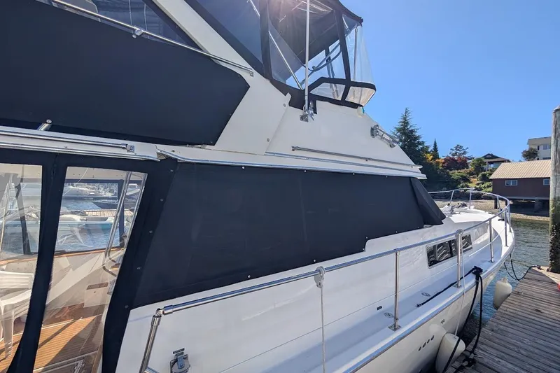 Slide: The Image of 1989 Bayliner 3888 Motoryacht docked, featuring sleek design and spacious deck area. - 6