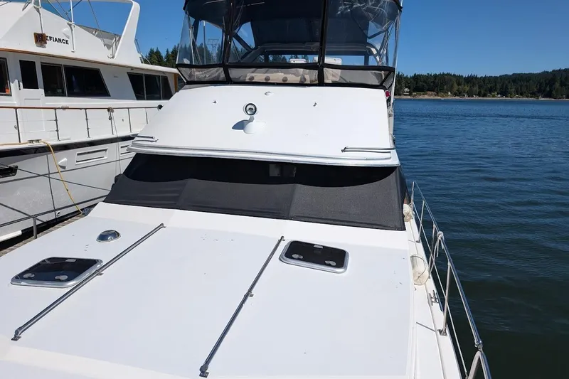 Slide: The Image of 1989 Bayliner 3888 Motoryacht docked on a sunny day, with clear blue water. - 9