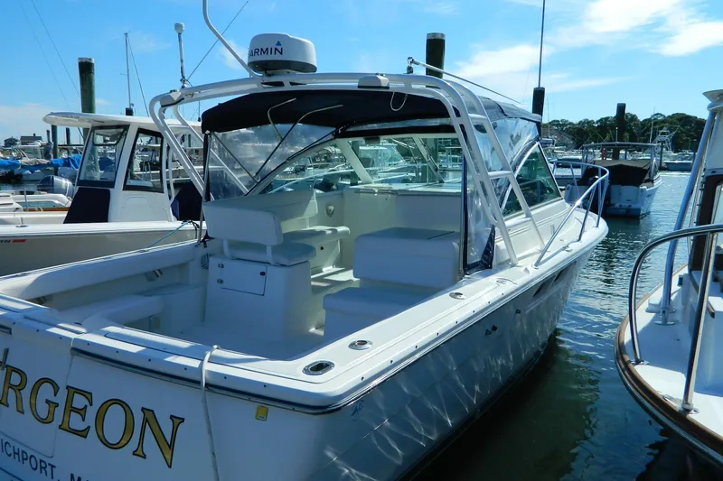 Slide: The Image of 1999 Tiara Yachts 2900 Coronet docked in a marina, featuring a spacious deck. - 13