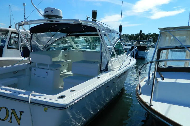 Slide: The Image of 1999 Tiara Yachts 2900 Coronet docked in a marina under clear skies. - 14