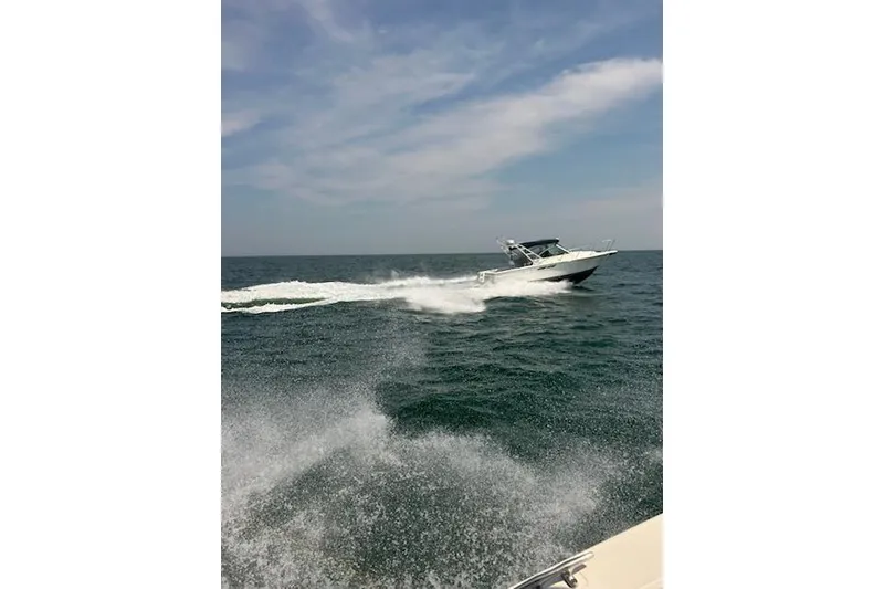 Slide: The Image of 1999 Tiara Yachts 2900 Coronet cruising on open water under a clear sky. - 16