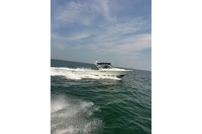 Slide: The Image of 1999 Tiara Yachts 2900 Coronet cruising on open water under a clear sky. - 18