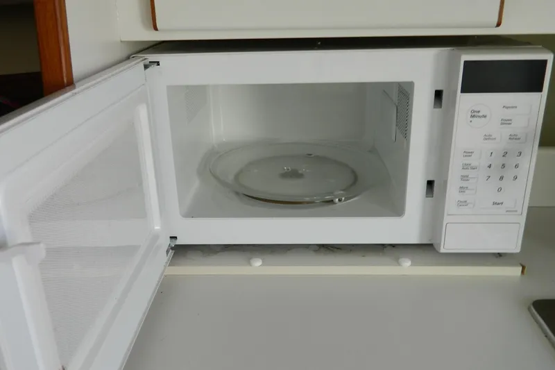 Slide: The Image of Open white microwave oven on a kitchen counter with visible control panel. - 7