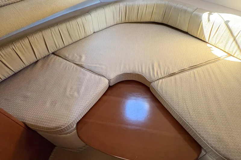 Slide: The Image of 2005 Meridian 368 Motoryacht interior seating area with beige cushions and wooden table. - 32