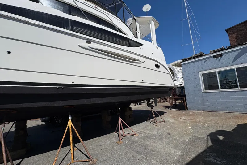 Slide: The Image of 2005 Meridian 368 Motoryacht on stands in a boatyard under clear blue sky. - 7