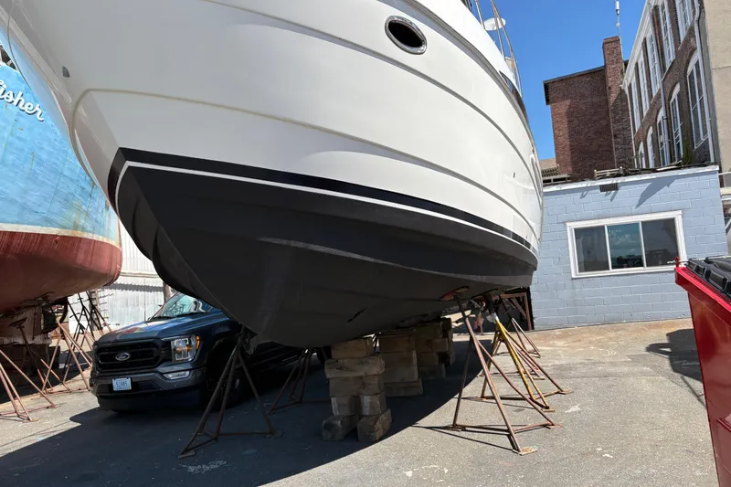 Slide: The Image of 2005 Meridian 368 Motoryacht on dry dock, supported by stands, near a blue building. - 72