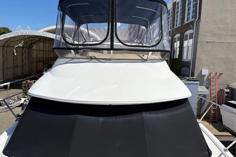 Slide: The Image of 2005 Meridian 368 Motoryacht with covered flybridge, docked near industrial buildings. - 9