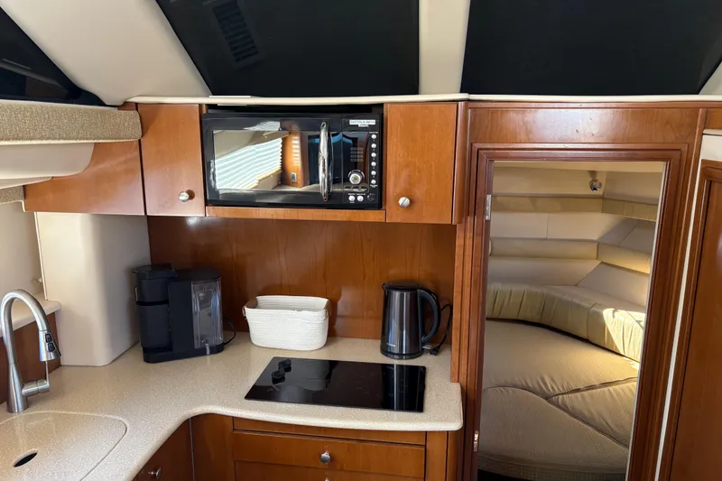 Slide: The Image of 2005 Meridian 368 Motoryacht kitchen with microwave, stove, and cozy cabin entrance. - 17
