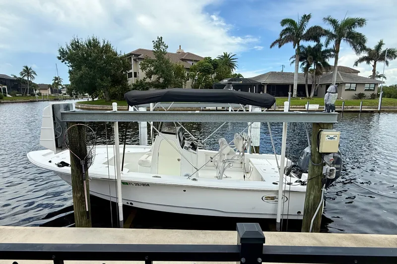 The Image of 2019 Sea Hunt BX 20 BR boat docked by waterfront homes with palm trees. - 0