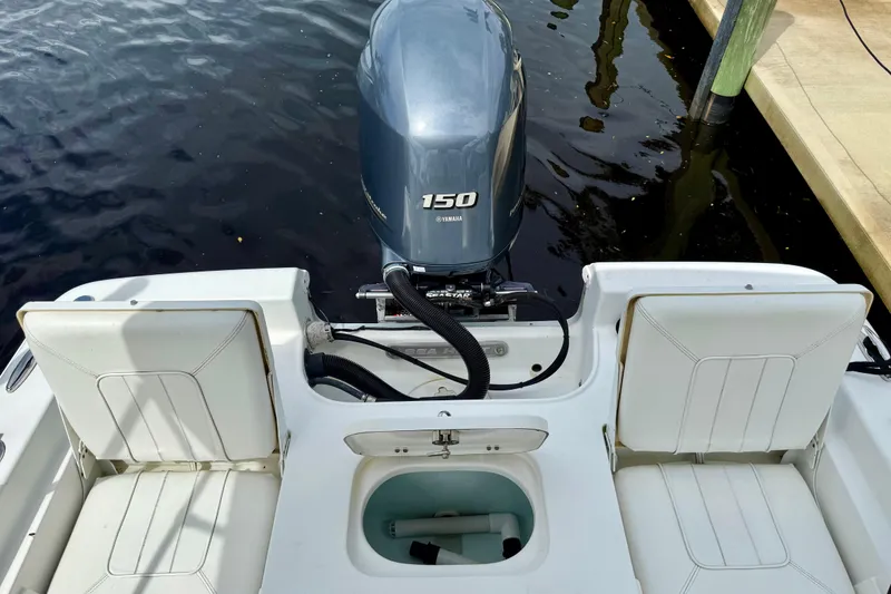 Slide: The Image of 2019 Sea Hunt BX 20 BR boat with Yamaha 150 engine, docked by the water. - 12