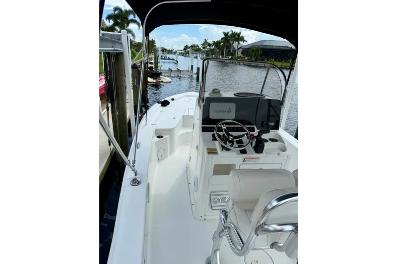 Slide: The Image of 2019 Sea Hunt BX 20 BR boat interior with Garmin navigation, docked by waterfront. - 13