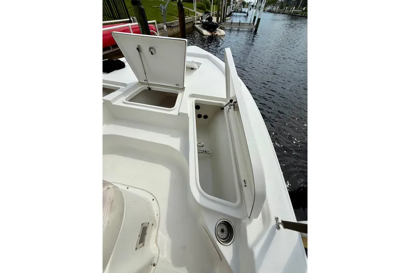 Slide: The Image of 2019 Sea Hunt BX 20 BR boat with open storage compartments by the water. - 20