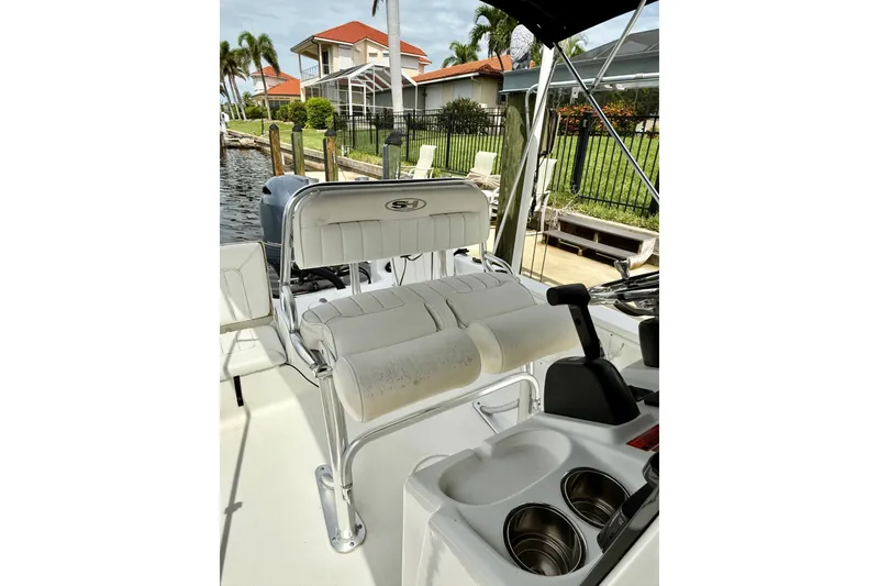 Slide: The Image of 2019 Sea Hunt BX 20 BR boat interior with seating and console, docked near waterfront homes. - 22
