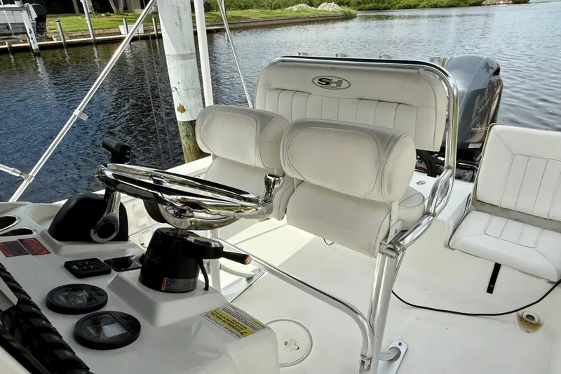 Slide: The Image of 2019 Sea Hunt BX 20 BR boat interior with steering wheel and seating by the water. - 23