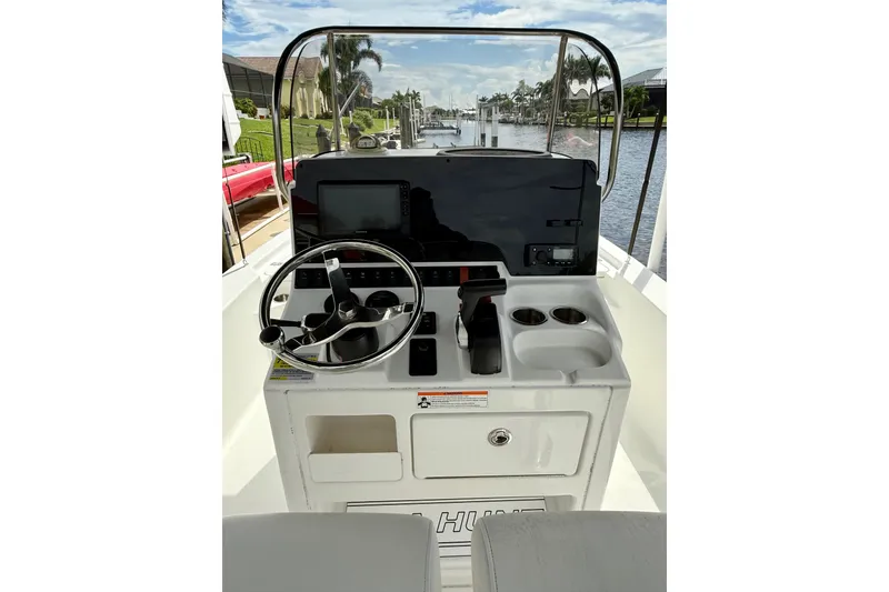 Slide: The Image of 2019 Sea Hunt BX 20 BR boat console with steering wheel and controls, docked by a canal. - 25