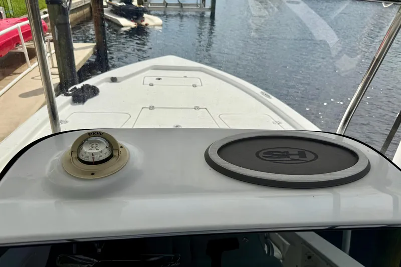 Slide: The Image of 2019 Sea Hunt BX 20 BR boat interior with compass and logo pad, docked by water. - 30