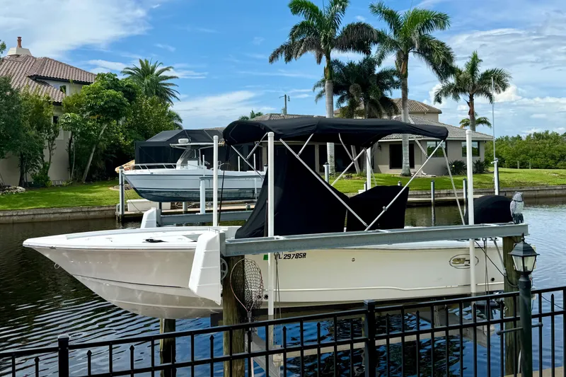 Slide: The Image of 2019 Sea Hunt BX 20 BR boat docked by waterfront homes with palm trees. - 31
