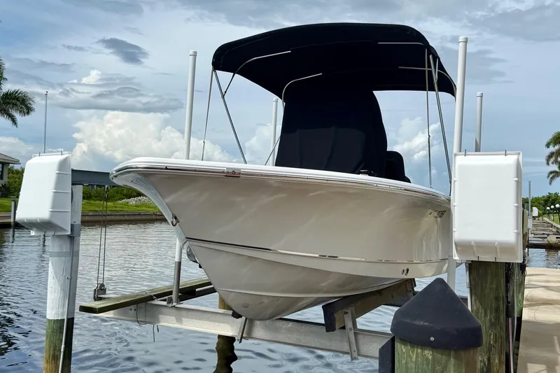 Slide: The Image of 2019 Sea Hunt BX 20 BR boat on lift, docked by a scenic waterfront. - 32