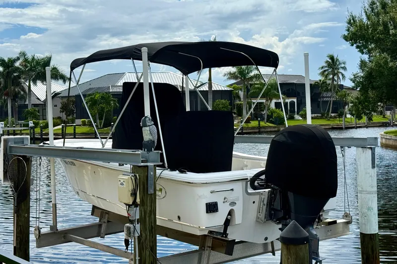Slide: The Image of 2019 Sea Hunt BX 20 BR boat on lift, covered, near waterfront homes. - 33