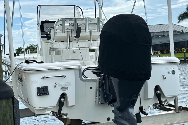 Slide: The Image of 2019 Sea Hunt BX 20 BR boat with covered outboard motor, docked by the water. - 34