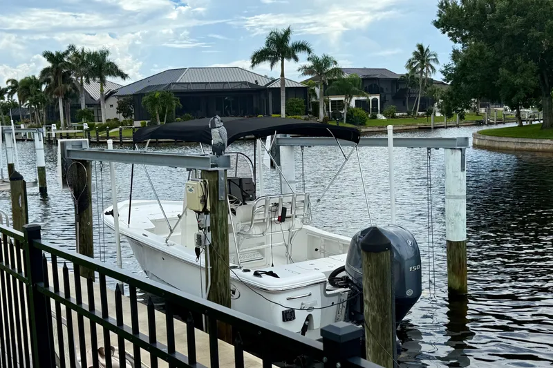 Slide: The Image of 2019 Sea Hunt BX 20 BR boat docked by waterfront homes with palm trees. - 4