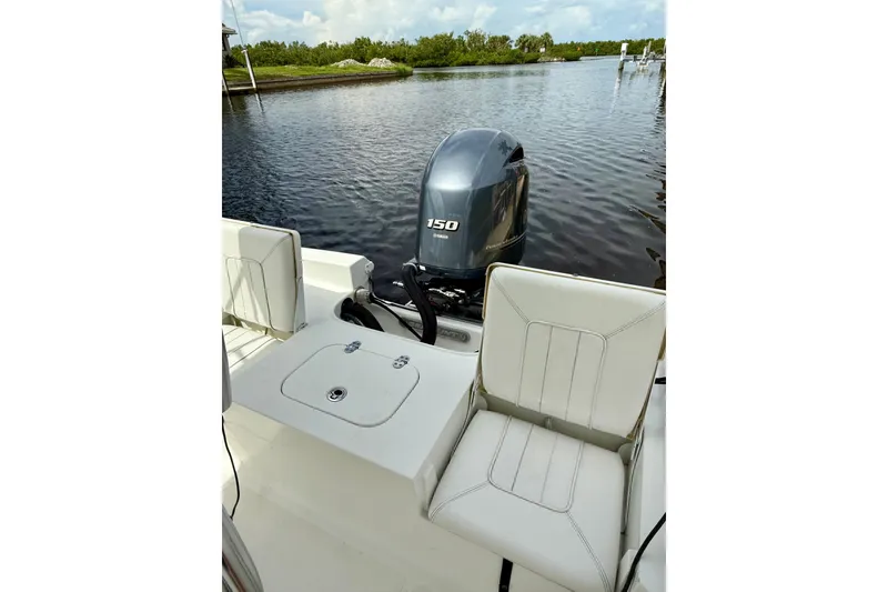 Slide: The Image of 2019 Sea Hunt BX 20 BR boat with Yamaha 150 engine, docked on calm water. - 9