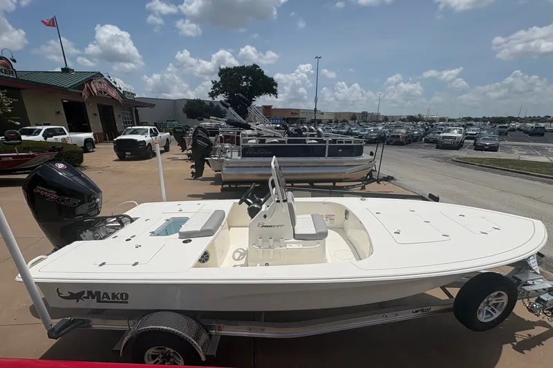 Slide: The Image of 2026 Mako 18 Pro Skiff boat on trailer at dealership under cloudy sky. - 8