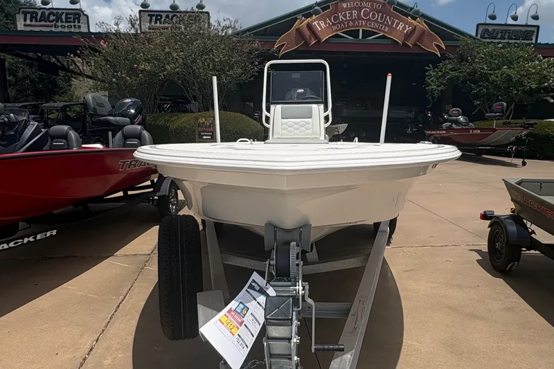 Slide: The Image of 2026 Mako 18 Pro Skiff boat on trailer under a sunny sky at dealership. - 1
