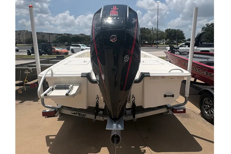 Slide: The Image of 2026 Mako 18 Pro Skiff boat with outboard motor, parked under a sunny sky. - 6