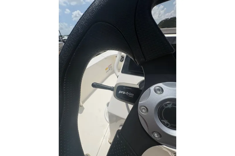 Slide: The Image of Steering wheel of 2026 Mako 18 Pro Skiff boat under sunny sky. - 18
