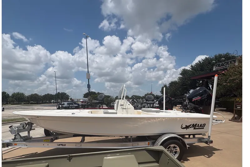 Slide: The Image of 2026 Mako 18 Pro Skiff boat on trailer under a partly cloudy sky. - 2