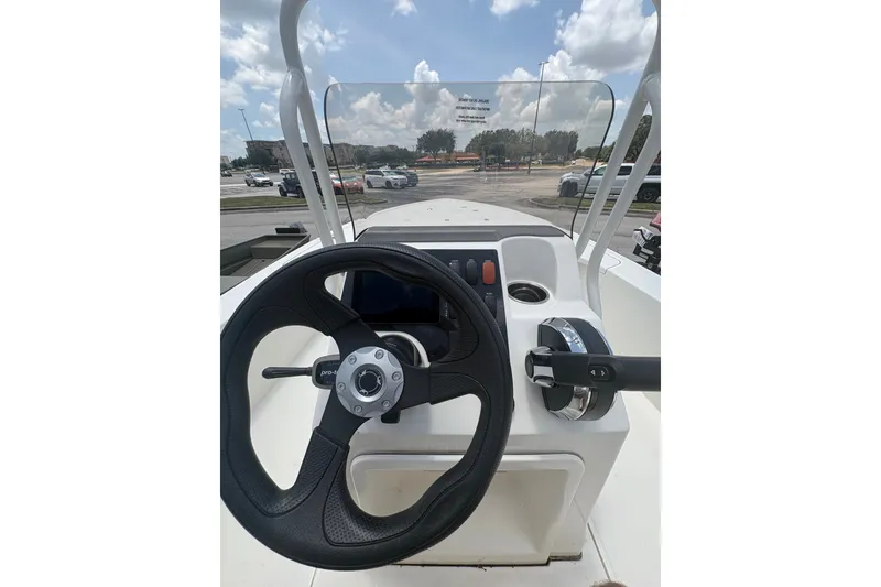 Slide: The Image of Steering console of 2026 Mako 18 Pro Skiff boat under a clear sky. - 16