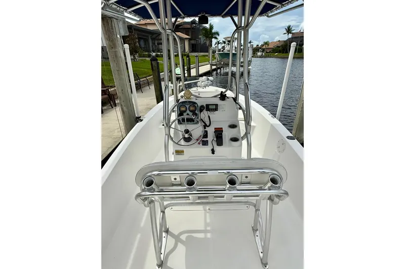 Slide: The Image of 2007 Sea Hunt BX 21 T boat interior with console and seating, docked by a canal. - 18