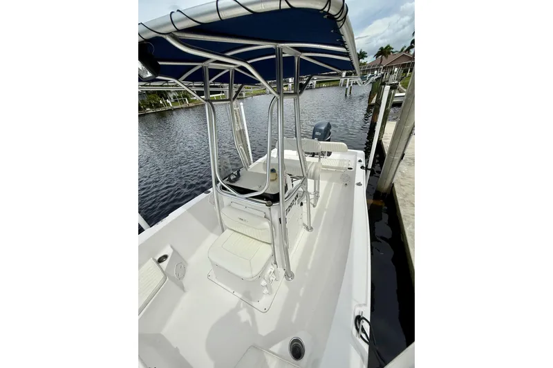 Slide: The Image of 2007 Sea Hunt BX 21 T boat with T-top, docked by a calm waterfront. - 23