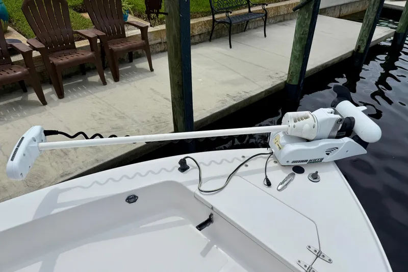 Slide: The Image of 2007 Sea Hunt BX 21 T boat with trolling motor docked by wooden chairs. - 25