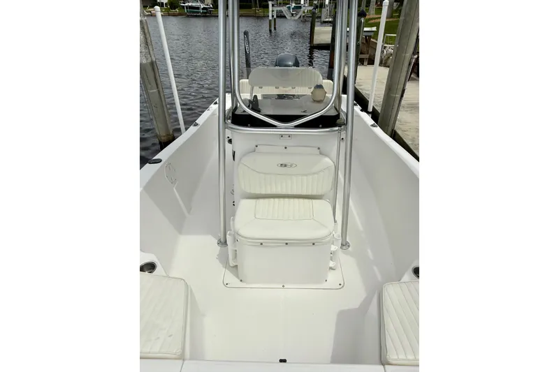Slide: The Image of 2007 Sea Hunt BX 21 T boat interior with seating and console, docked by the water. - 27