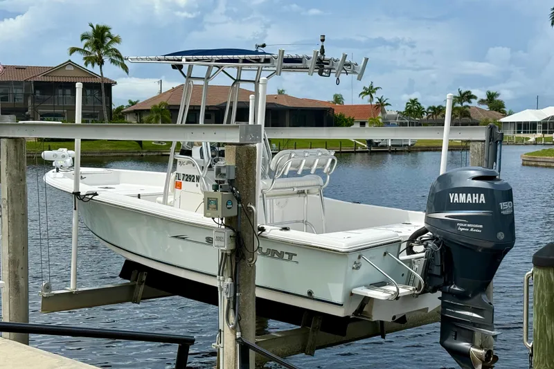 Slide: The Image of 2007 Sea Hunt BX 21 T boat with Yamaha motor on a lift by waterfront homes. - 3