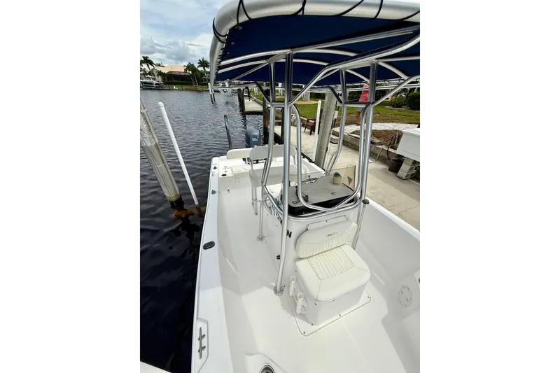 Slide: The Image of 2007 Sea Hunt BX 21 T boat with canopy, docked by a waterfront. - 30