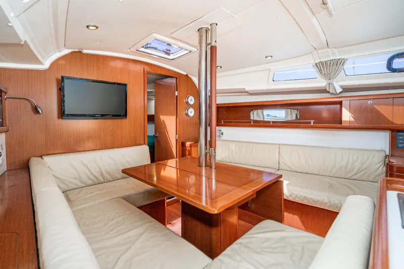 Slide: The Image of Interior of 2011 Beneteau Oceanis 37 yacht with cozy seating and wooden finishes. - 11