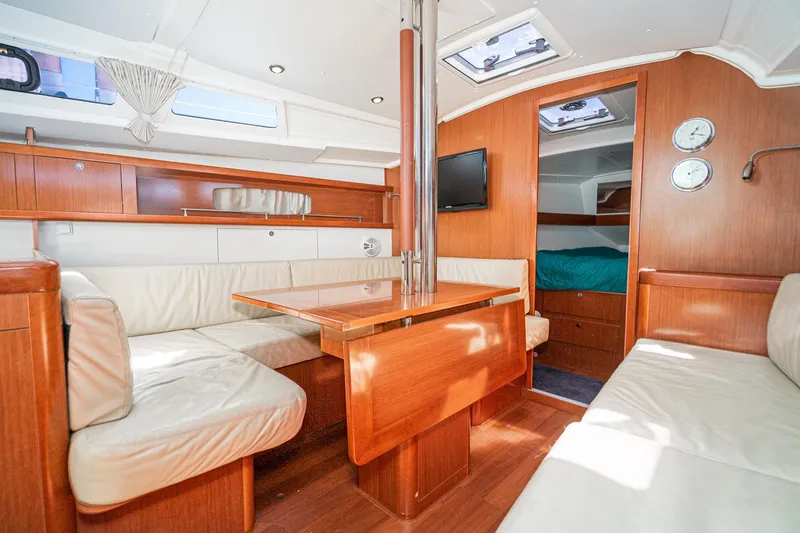 Slide: The Image of Interior of 2011 Beneteau Oceanis 37 yacht with wood finish and cozy seating area. - 12