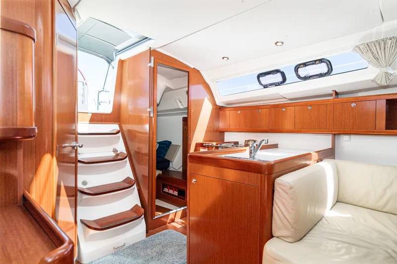 Slide: The Image of Interior of 2011 Beneteau Oceanis 37 yacht with wooden cabinetry and cozy seating area. - 16