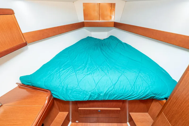 Slide: The Image of Cozy cabin interior of 2011 Beneteau Oceanis 37 with teal bedding and wooden accents. - 24