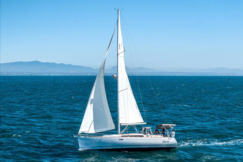 Slide: The Image of 2011 Beneteau Oceanis 37 sailing on open sea with distant mountains. - 4