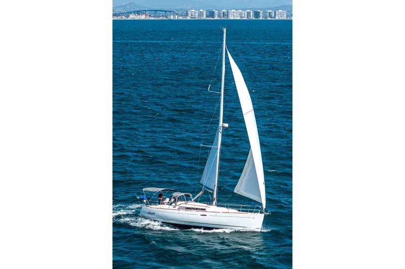 Slide: The Image of 2011 Beneteau Oceanis 37 sailing on open sea with cityscape in background. - 7