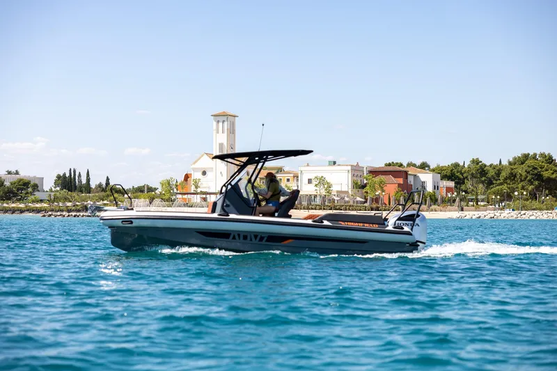 Slide: The Image of 2026 Highfield ADV7 boat cruising on blue water near coastal buildings. - 2