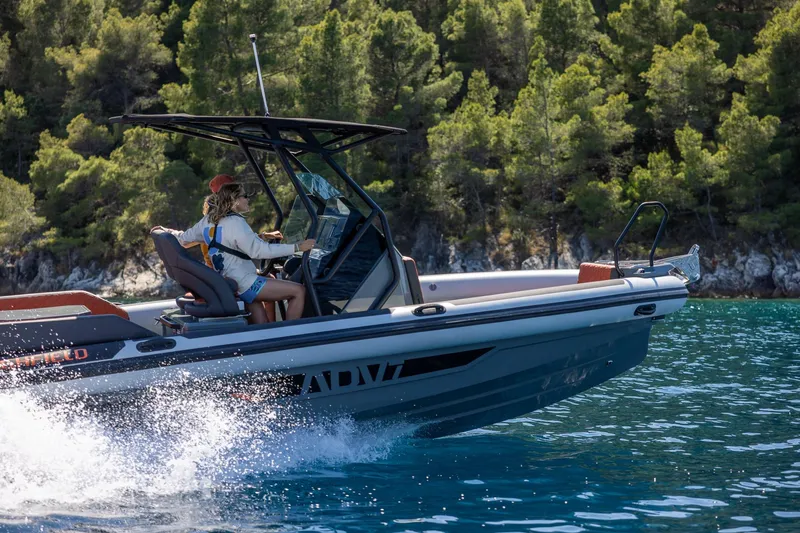 Slide: The Image of 2026 Highfield ADV7 boat cruising on clear water near a forested shoreline. - 4