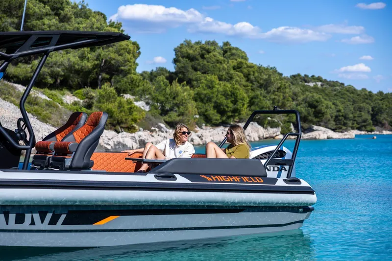 Slide: The Image of 2026 Highfield ADV7 boat on turquoise water with two people relaxing onboard. - 8