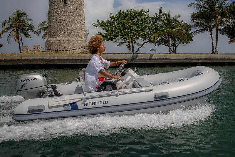 Slide: The Image of Manufacturer Provided Image: 2024 Highfield Classic 360 FCT inflatable boat cruising near a lighthouse. - 1