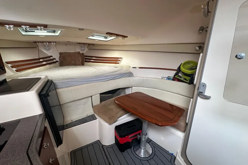 Slide: The Image of 2008 Grady-White Express 330 cabin interior with bed, table, and storage. - 47